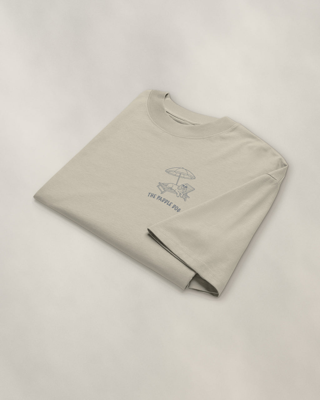 Marbella Chapter Tee - Stone, folded, the crest on the chest